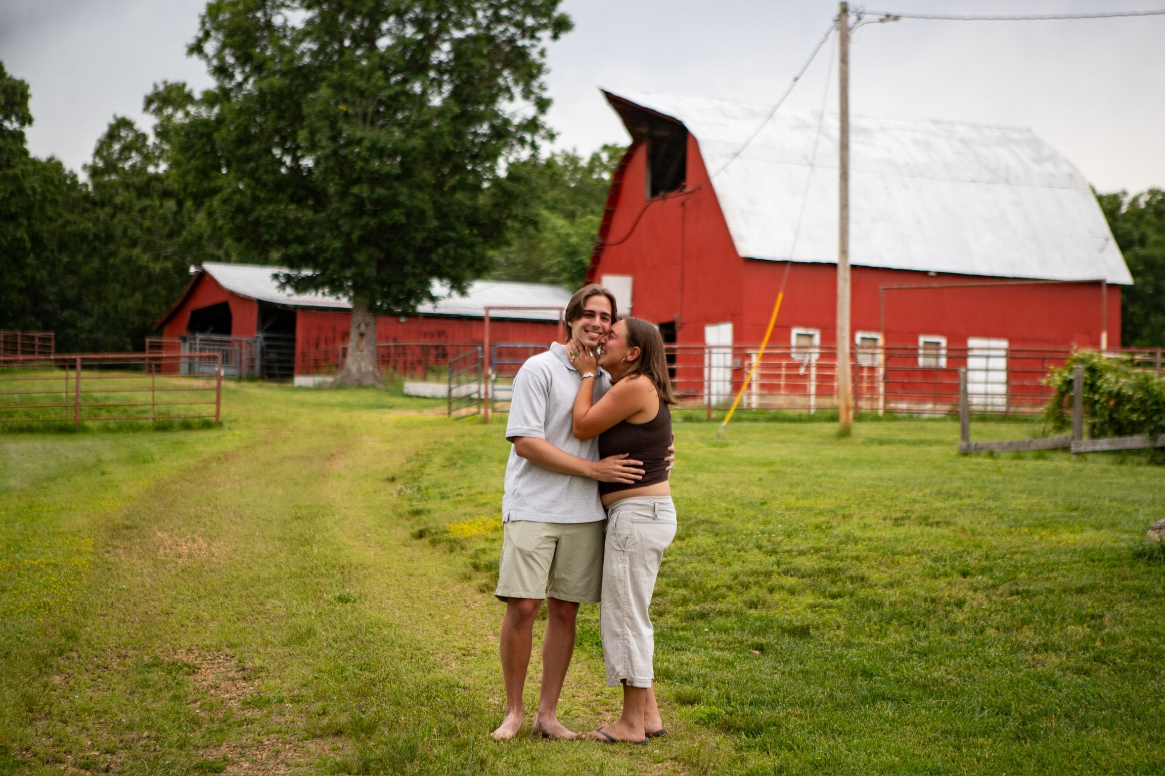 Andrew and Grace smiling together in front of the red barn