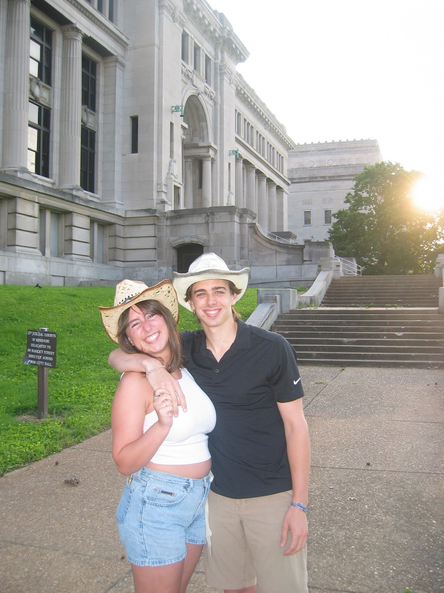 Andrew and Grace in cowboy hats in front of a stone building