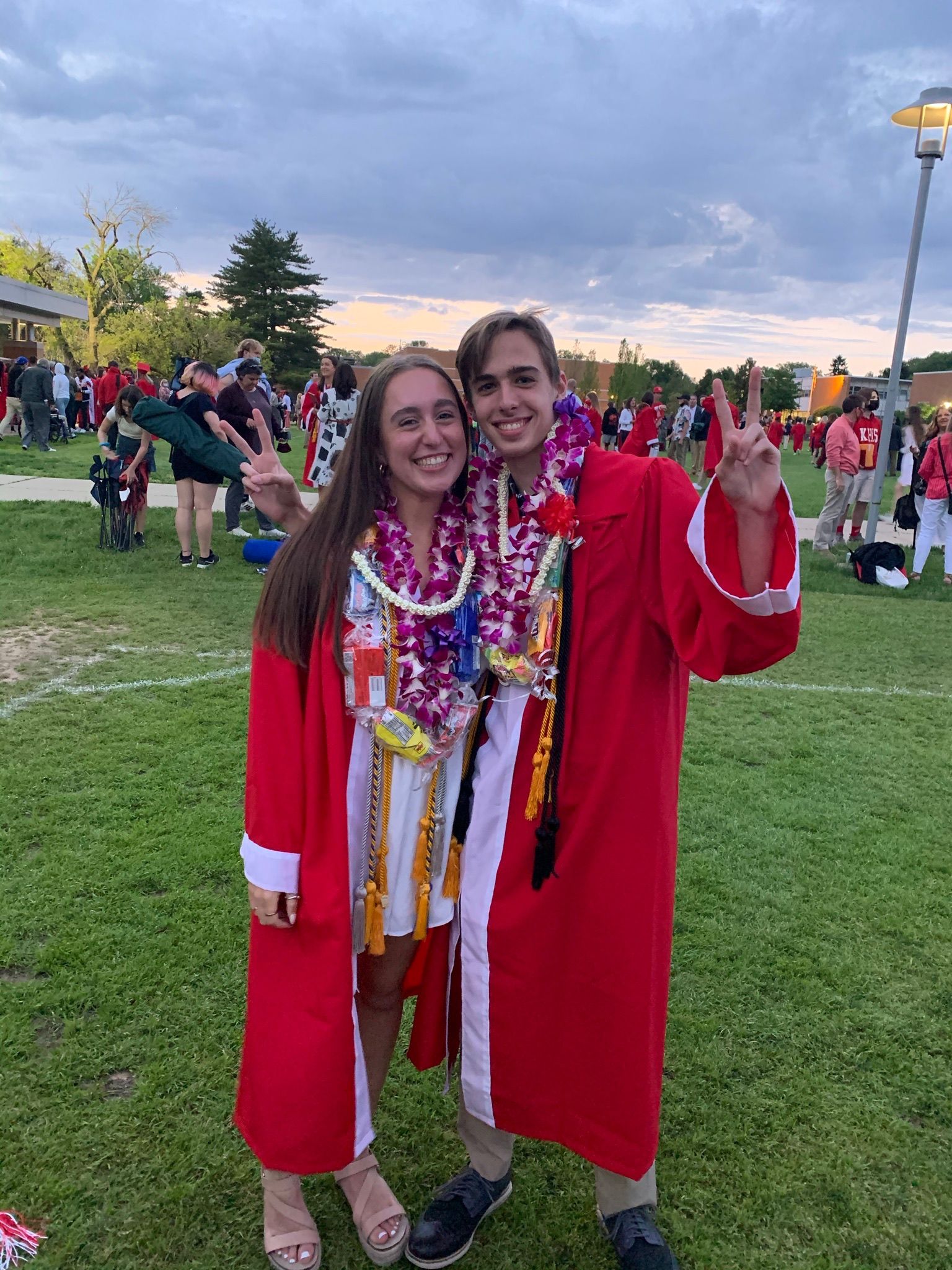 Andrew and Grace in red graduation gowns and leis