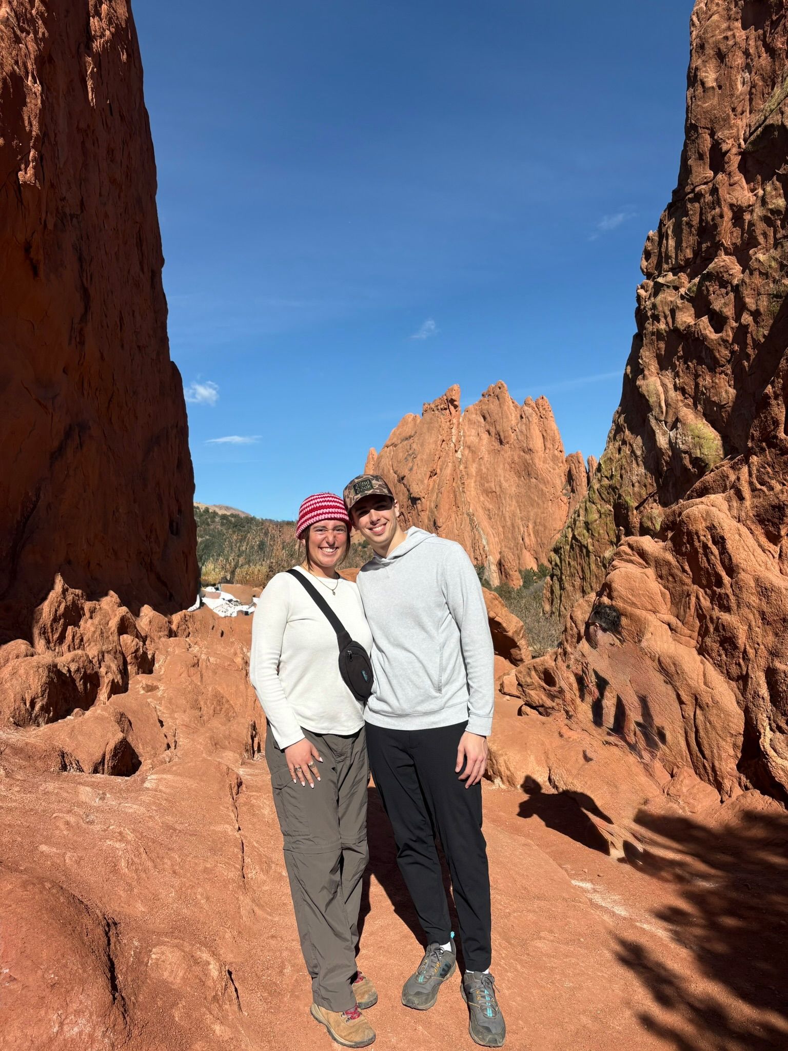 Andrew and Grace hiking among tall red rock formations